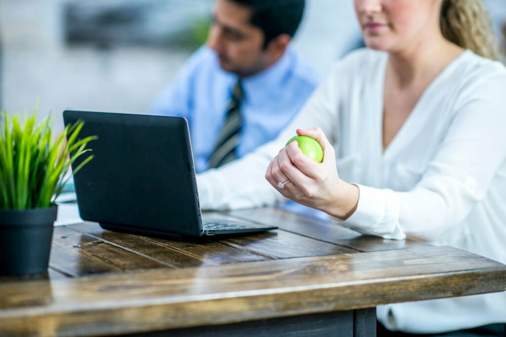 femme avec une balle anti stress sur une table en bois